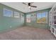 Green-painted bedroom with a ceiling fan, neutral carpet, and natural light from three windows at 4688 Cedar Glen Pl, Castle Rock, CO 80109