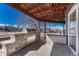 Outdoor kitchen complete with built-in grill and covered dining area at 4688 Cedar Glen Pl, Castle Rock, CO 80109