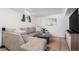 Basement rec room with comfortable sectional, hardwood floors, and a mounted flat screen TV at 10983 W Exposition Pl, Lakewood, CO 80226