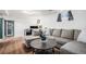Finished basement featuring a comfortable sectional, hardwood floors, and a home office at 10983 W Exposition Pl, Lakewood, CO 80226