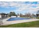 Community pool covered for off-season use, set against a backdrop of mature trees and a clear blue sky at 10983 W Exposition Pl, Lakewood, CO 80226