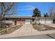 Split-level home showcasing attached garages, a brick facade, and a long driveway at 10983 W Exposition Pl, Lakewood, CO 80226