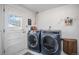 Laundry room features modern washer and dryer units with a patterned tile floor at 10983 W Exposition Pl, Lakewood, CO 80226