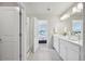 Bright bathroom features double sinks, a glass shower, and an open doorway to a bedroom at 21091 E 63Rd Dr, Aurora, CO 80019
