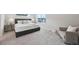 Carpeted primary bedroom features a comfortable bed, soft lighting, and a sitting area at 21091 E 63Rd Dr, Aurora, CO 80019