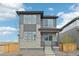 Modern two-story home with gray siding, stone accents, professional landscaping, and covered porch at 21091 E 63Rd Dr, Aurora, CO 80019