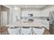Bright kitchen features white cabinets, stainless steel appliances, and a large island with bar seating at 21091 E 63Rd Dr, Aurora, CO 80019