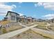 New construction homes line the street with sidewalks and common green spaces at 21091 E 63Rd Dr, Aurora, CO 80019