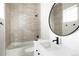 Contemporary bathroom with a soaking tub, gray tiled shower walls and a round black framed mirror at 3022 Fenton St, Wheat Ridge, CO 80214