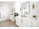 Bright bathroom features double sinks, white cabinets, gold hardware, and modern mirrors at 3022 Fenton St, Wheat Ridge, CO 80214