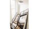 Open staircase with wood treads, black metal railings and modern chandelier, bright and open space at 3022 Fenton St, Wheat Ridge, CO 80214