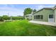Beautifully landscaped backyard featuring lawn, lush hedges, and concrete patio at 6811 S Clermont Dr, Centennial, CO 80122