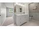 This bathroom has white marble wall tiles, a large mirror, and white sink at 6811 S Clermont Dr, Centennial, CO 80122