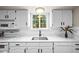 All-white kitchen, featuring modern appliances, stone countertops, and a view to the backyard at 6811 S Clermont Dr, Centennial, CO 80122