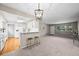 Open concept living room flows into the kitchen with bar seating and modern pendant lighting at 6811 S Clermont Dr, Centennial, CO 80122