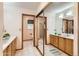 En suite bathroom with dual sinks, mirrors, vanities and shower over bath reflected in sliding mirrored wardrobe at 10365 E Weaver Cir, Englewood, CO 80111