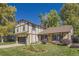 Beautifully landscaped front yard with a Tudor-style home featuring a two-car garage and swing at 10365 E Weaver Cir, Englewood, CO 80111