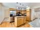A well-lit kitchen featuring stainless steel appliances, wood cabinets and a center island at 10365 E Weaver Cir, Englewood, CO 80111