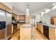 A well-lit kitchen featuring stainless steel appliances, wood cabinets and a center island at 10365 E Weaver Cir, Englewood, CO 80111