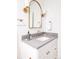 Bright bathroom with grey counter, white vanity, and gold fixtures at 1880 S Adams St, Denver, CO 80210