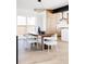 Modern dining area with stylish lighting, neutral tones and view to kitchen at 1880 S Adams St, Denver, CO 80210