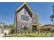 Two-story home with gray brick, black trim, a peaked roof, and a well-kept lawn at 1880 S Adams St, Denver, CO 80210