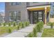 Home's entryway features modern black framed glass door, elegant address marker, and manicured landscaping at 1880 S Adams St, Denver, CO 80210