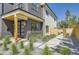 Home's elegant entrance has a wood-accented porch, black door, concrete walkway, and manicured landscaping at 1880 S Adams St, Denver, CO 80210