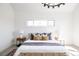 Sun-filled main bedroom features neutral decor, bench, and stylish lighting fixture at 1880 S Adams St, Denver, CO 80210