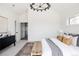 Spacious main bedroom with woven bench, decorative chandelier, and ample natural light at 1880 S Adams St, Denver, CO 80210