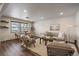 Inviting living room featuring an open-concept layout, modern furniture, hardwood flooring, and abundant natural light at 6048 Xenon St, Arvada, CO 80004