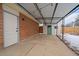 Covered patio area featuring string lights, access to storage shed with stylish teal door and a brick wall at 6048 Xenon St, Arvada, CO 80004