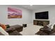 Cozy living room with a large TV, leather sectional sofa, carpeted floor, and mountain view artwork at 12938 Bridge View Ln, Parker, CO 80134