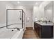Bathroom featuring dual sinks, granite countertops, a soaking tub, and a glass enclosed shower at 2303 Angus St, Mead, CO 80542