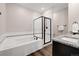 This bathroom features dual sinks, a soaking tub, and a glass shower with dark hardware at 2303 Angus St, Mead, CO 80542