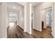 Bright hallway with hard wood floors leading to living spaces and a bathroom at 2303 Angus St, Mead, CO 80542