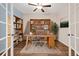 Bright office space featuring French doors, built-in shelves, and a wooden desk at 2303 Angus St, Mead, CO 80542