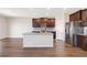 Open kitchen features an island with granite countertops, dark cabinets, and stainless steel appliances at 2303 Angus St, Mead, CO 80542