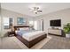 Spacious main bedroom features a ceiling fan, large window, and access to the ensuite bathroom at 2303 Angus St, Mead, CO 80542