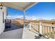 Covered patio with white railing offering views of the backyard and surrounding landscape at 2303 Angus St, Mead, CO 80542