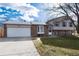 Two-story house with a white garage door, brick accents, and a grassy yard at 8152 S Everett St, Littleton, CO 80128