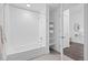 Bright bathroom features shower-tub combo with tiled walls, open linen shelving, and access to bedroom at 2525 Arapahoe St # Rd315, Denver, CO 80205