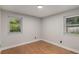 Bright bedroom boasts neutral walls and new wood flooring, complemented by two windows at 10051 E Walsh Pl, Denver, CO 80247
