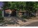 Charming single-story home with a brick facade, mature trees, and a two-car garage at 10051 E Walsh Pl, Denver, CO 80247