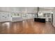 Spacious living room featuring hardwood floors, natural light, and an open layout to the kitchen at 10051 E Walsh Pl, Denver, CO 80247