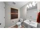 Bathroom features a pedestal sink, white fixtures, and decorative artwork at 17145 W 91St Ln, Arvada, CO 80007