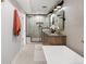 Bright bathroom featuring a glass-enclosed shower, a wooden double vanity, and a modern soaking tub at 2395 N Emerson St, Denver, CO 80205