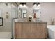 Modern bathroom with double vanity, wood cabinets, a glass-enclosed shower, and gold fixtures at 2395 N Emerson St, Denver, CO 80205