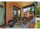Cozy front porch with brick pillars, wood ceiling, and seating with an outdoor rug at 2395 N Emerson St, Denver, CO 80205