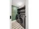 Compact laundry room with a stacked washer and dryer and built-in storage shelves at 2395 N Emerson St, Denver, CO 80205